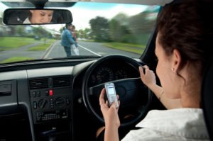 Driver distracted by using a phone while approaching pedestrians crossing the road.