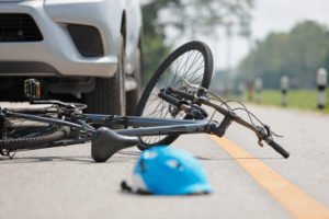 A helmet and bike lying on the ground after a car accident