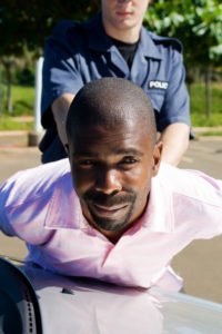 Driver arrested against the hood of his car.