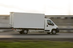 A moving van speeding on a highway.