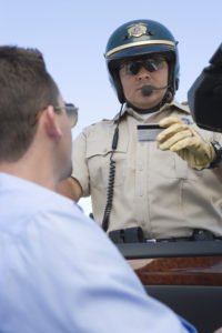 A police officer looking at a driver’s license.