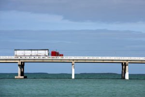 A tractor-trailer driving across a Florida bridge.