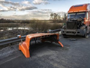 A tractor-trailer missing its hood after an accident.