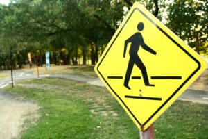 person walking street sign