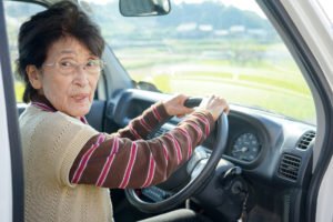 elderly person driving a car