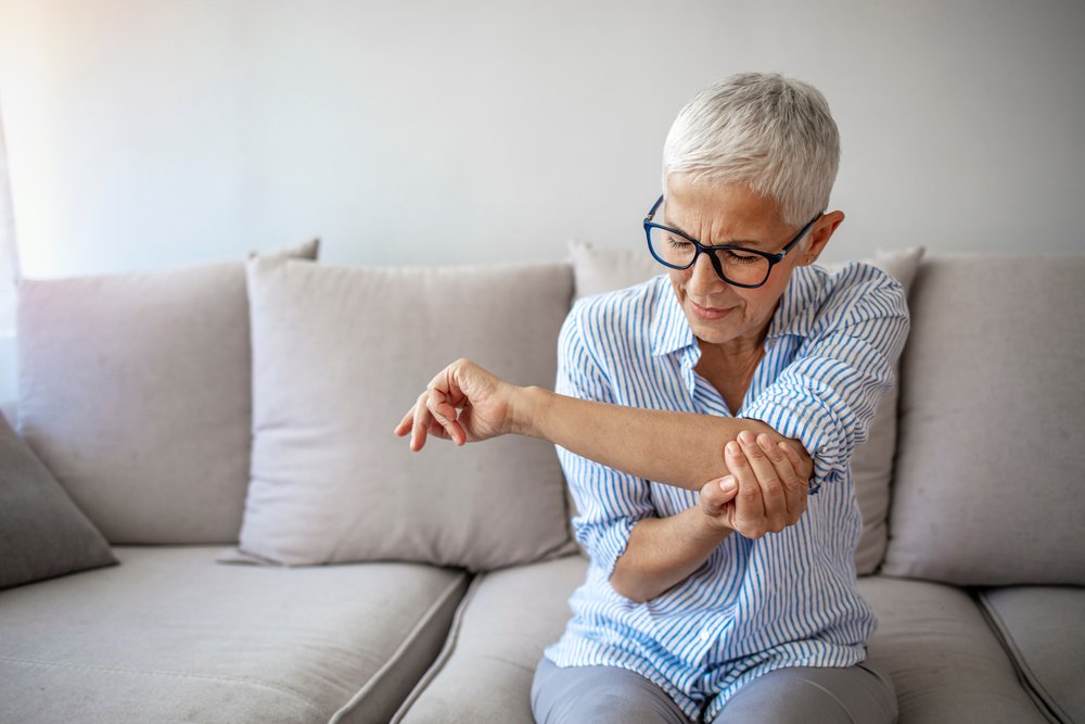 woman with elbow pain on the couch