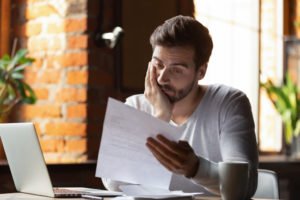 man struggling to make sense of paperwork