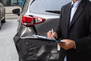 insurance adjuster inspects the damage after collision