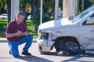 insurance adjuster inspects vehicle damage