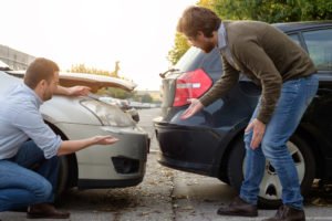 two drivers check for damage after a collision