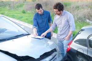 two motorists exchange insurance after accident