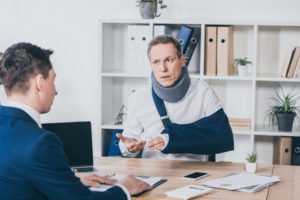 injured man discusses workers comp with a lawyer