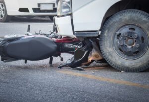 motorcycle lodged under a truck