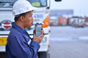 truck driver blowing into a breathalyzer